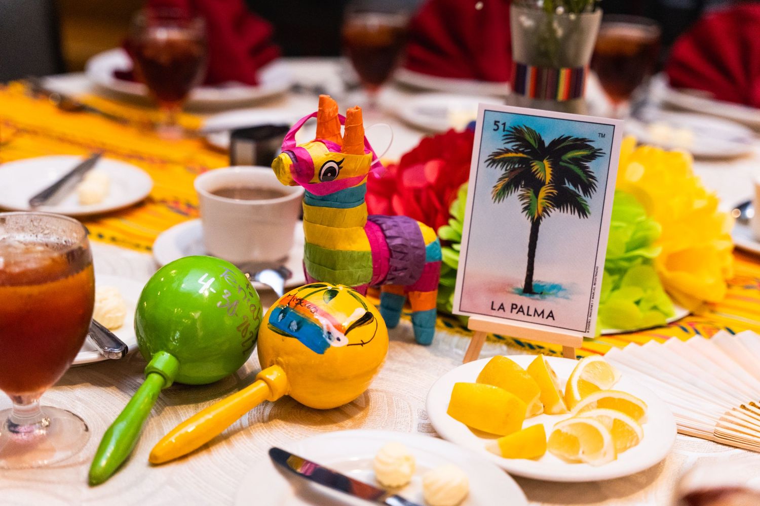 Colorful table setting with tropical decorations including a pinata and La Palma card.