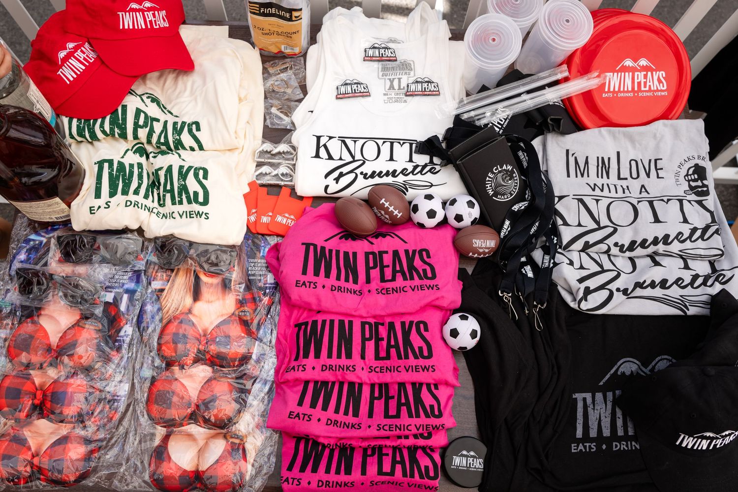Display of branded merchandise and t-shirts at Twin Peaks event booth.