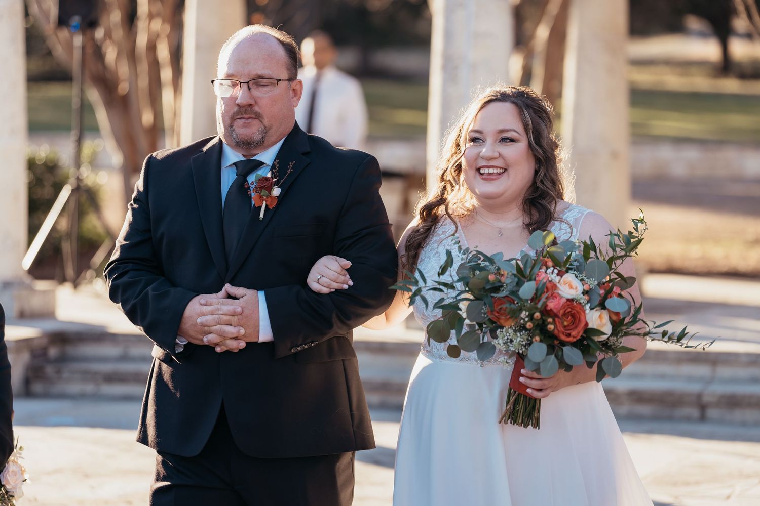 Joyful moment during outdoor wedding ceremony with floral bouquet.