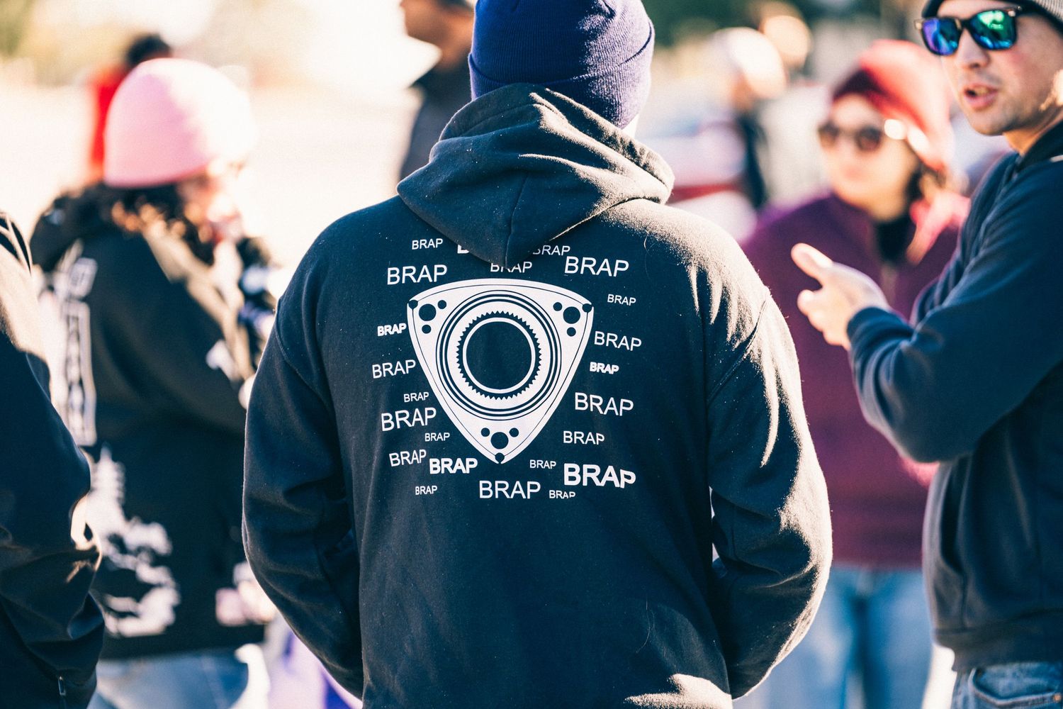 Black hoodie with rotary engine diagram printed on the back at a car meet.