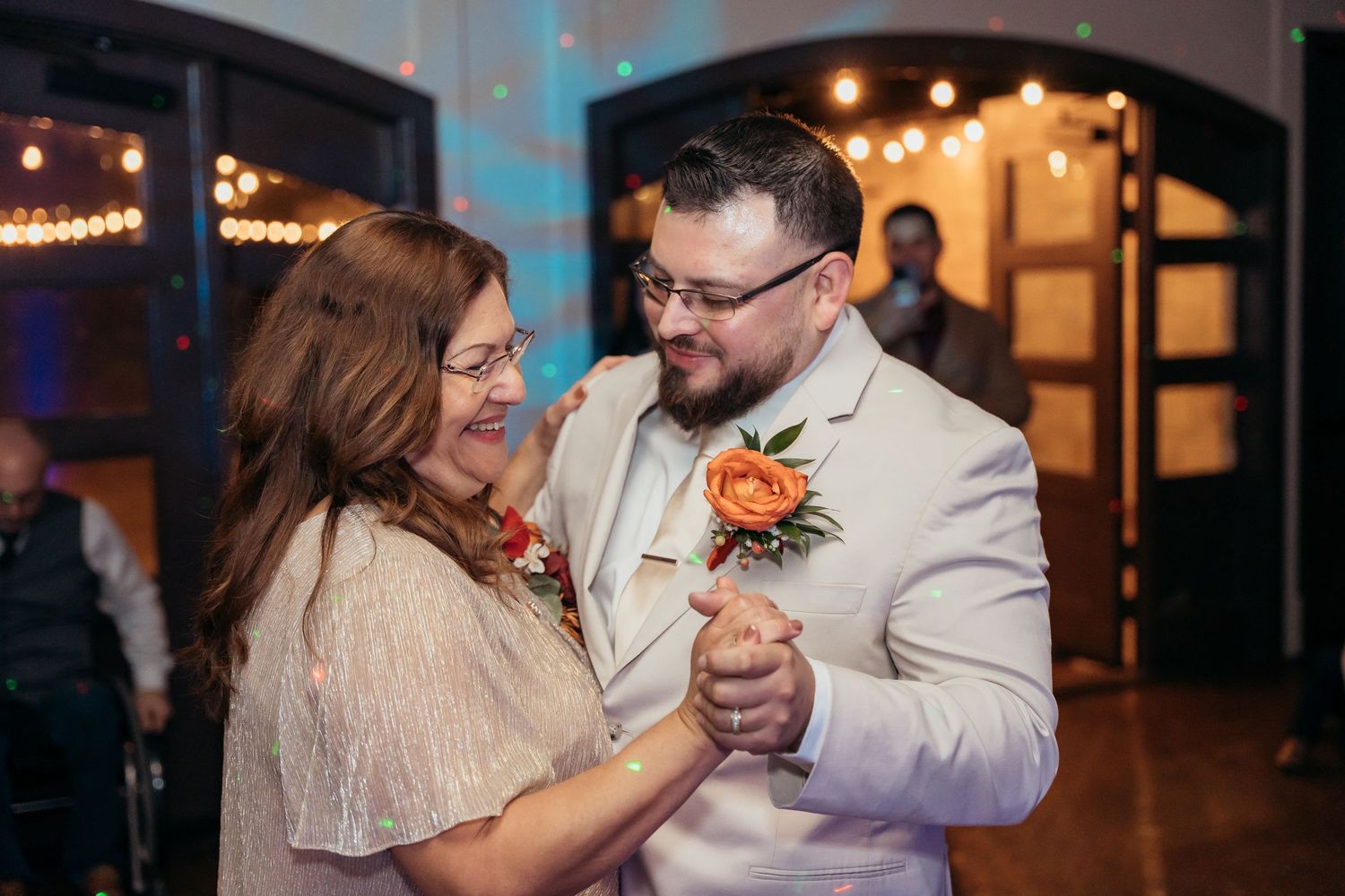 Wedding couple sharing an intimate dance moment under warm indoor lighting.