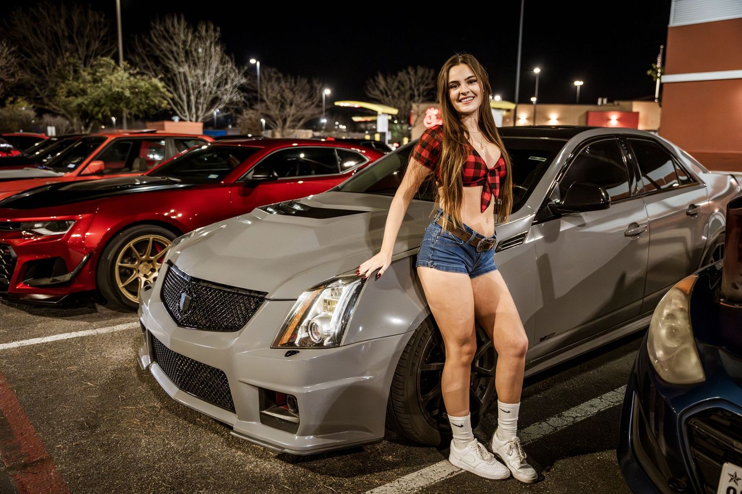 Modified Cadillac CTS-V sedan parked at a nighttime car meet.