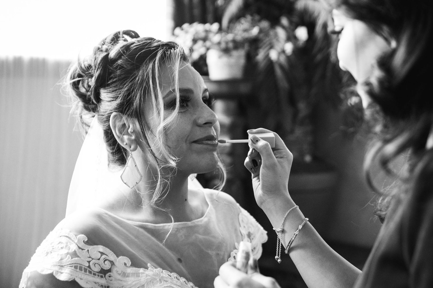 Final touches of makeup being applied during bridal preparation.