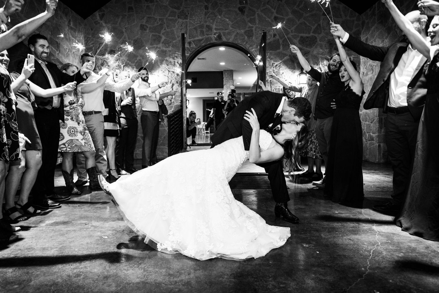 A dramatic black and white photo of a couple's sparkler exit during their wedding reception.
