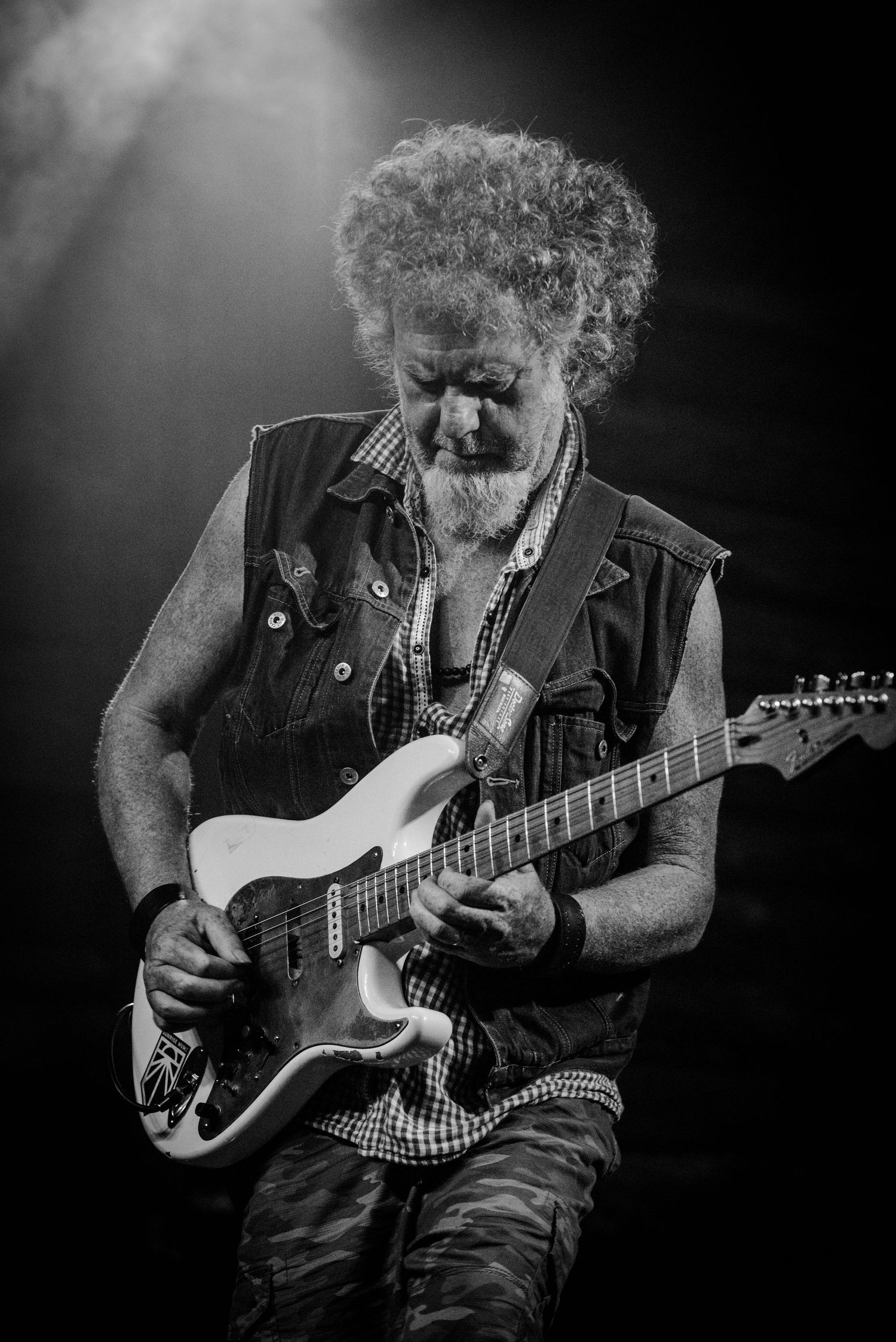 Black and white photo series of a guitarist playing electric guitar with dramatic lighting and expressive hand movements.