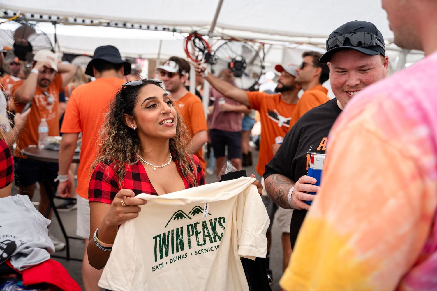 Fan showing off Twin Peaks merchandise at crowded outdoor event.