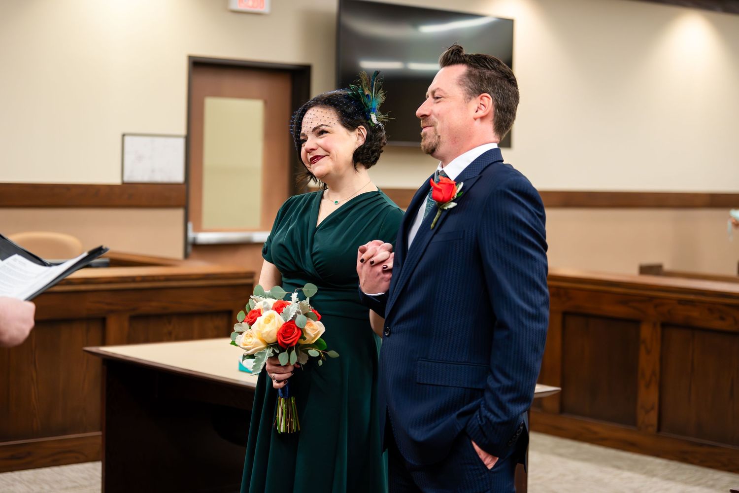 A couple shares a joyful moment during their courthouse wedding ceremony.