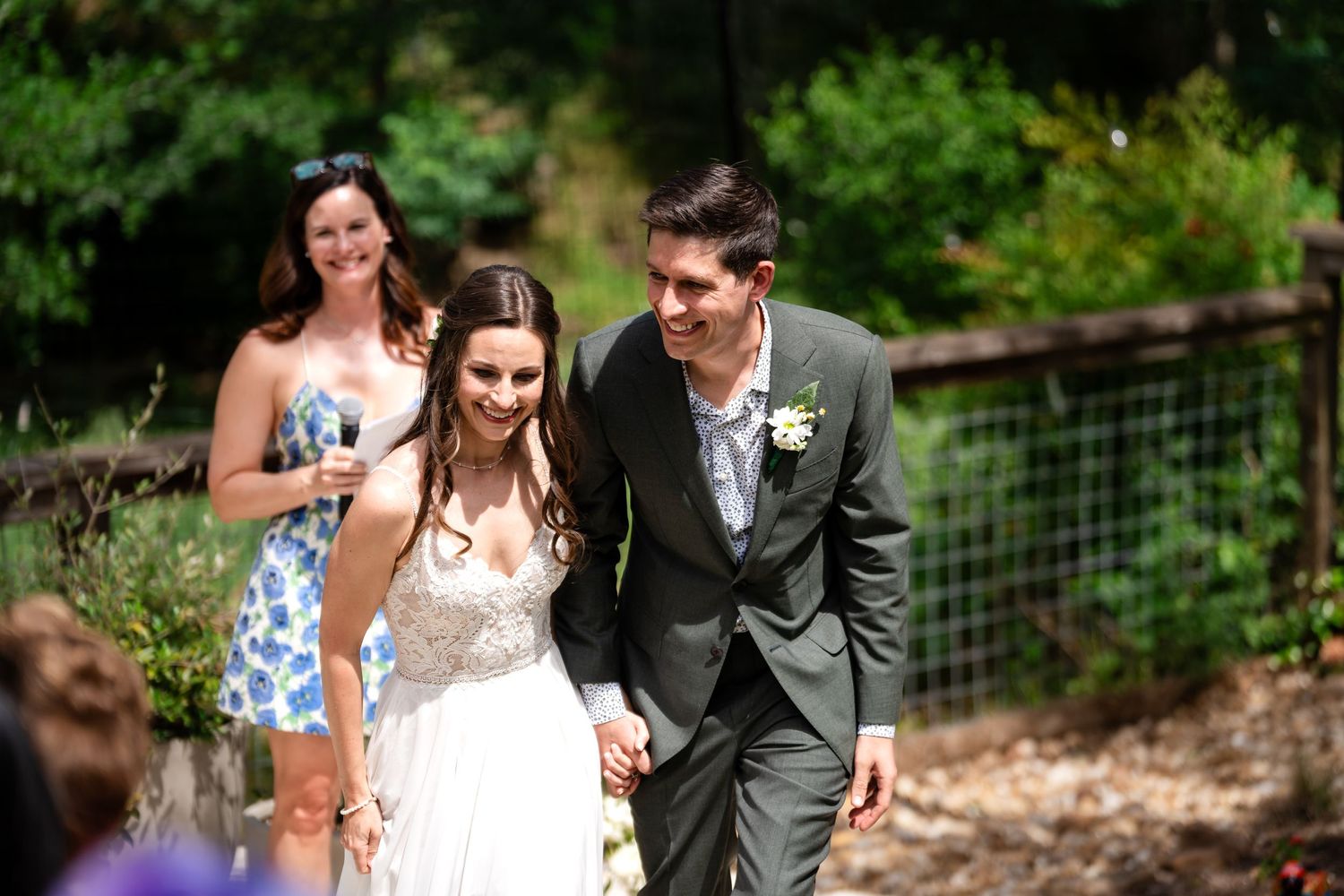 An emotional outdoor wedding ceremony moment with guests watching in a garden setting.