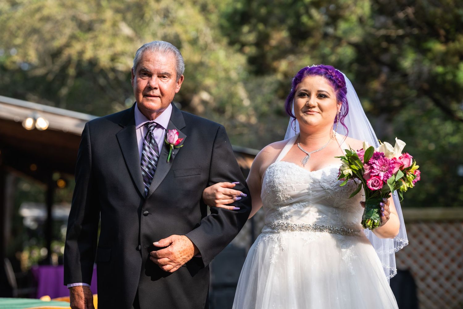A wedding processional moment captured in natural outdoor lighting.