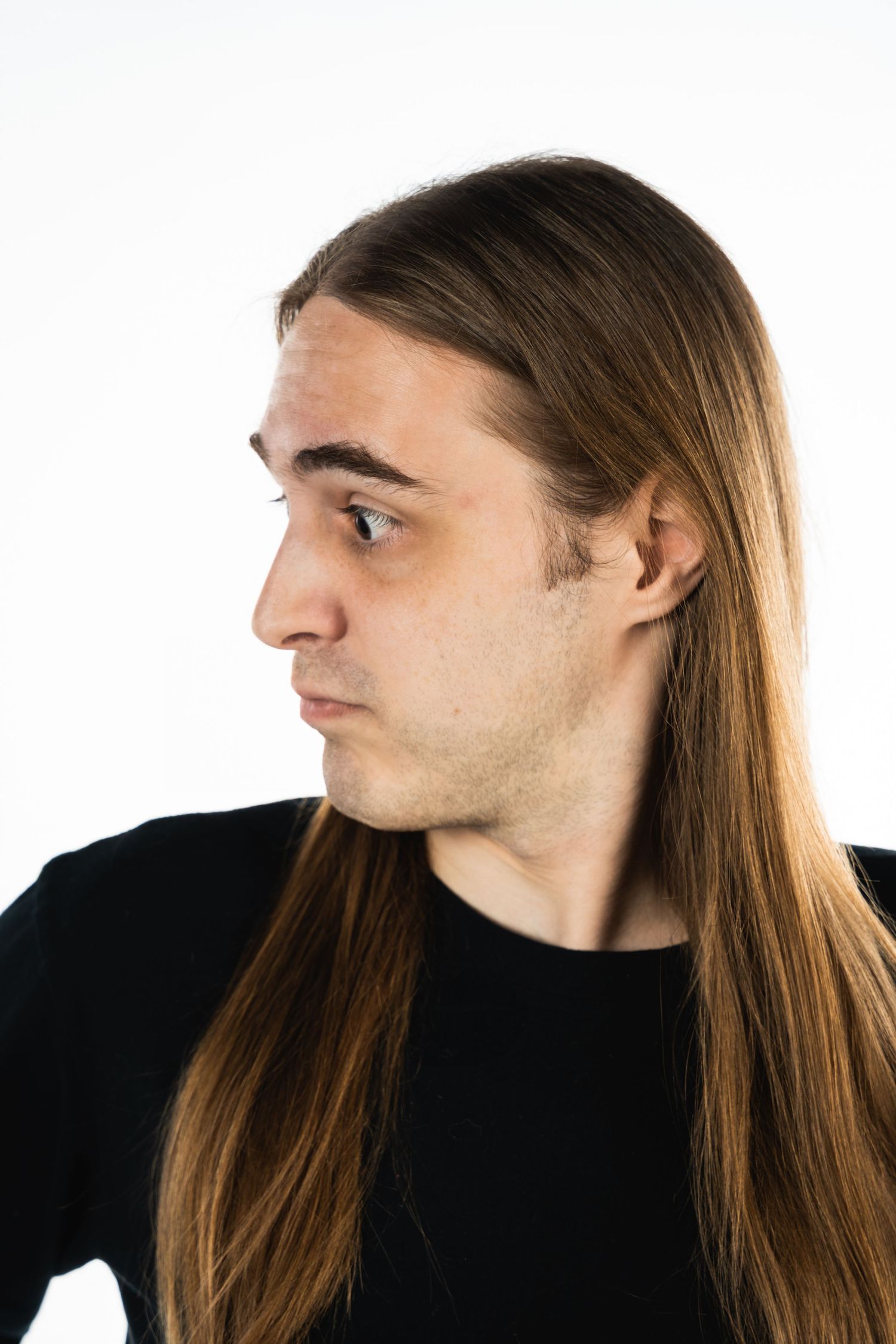 Profile portrait of a person with long straight brown hair against white background.