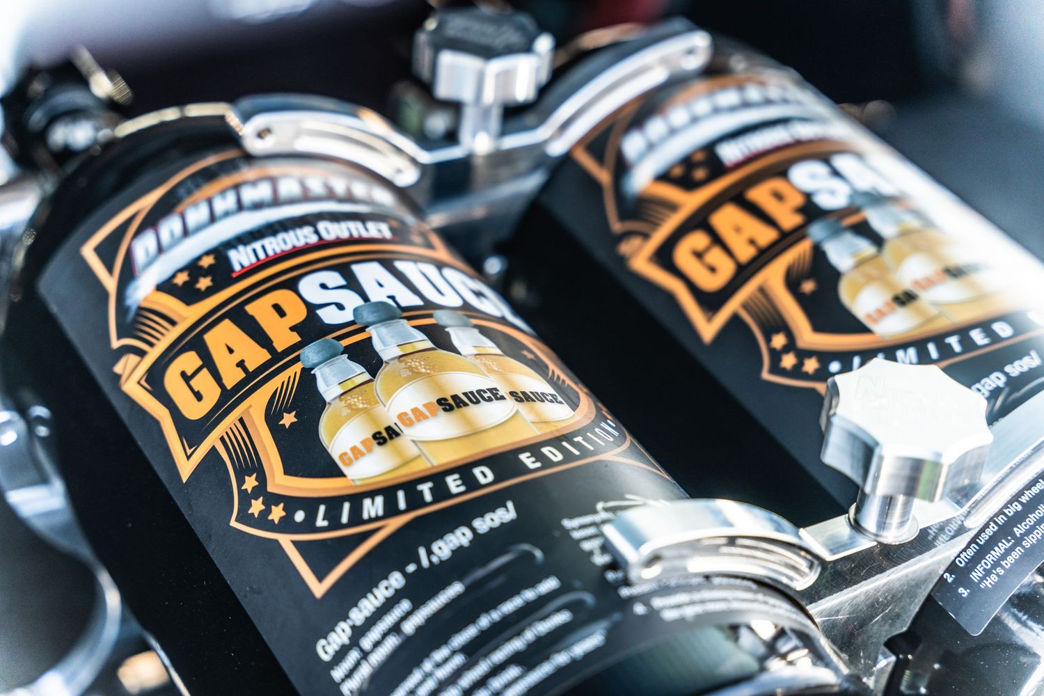 Two bottles of Cars & Coffee brand automotive products displayed on dark surface.