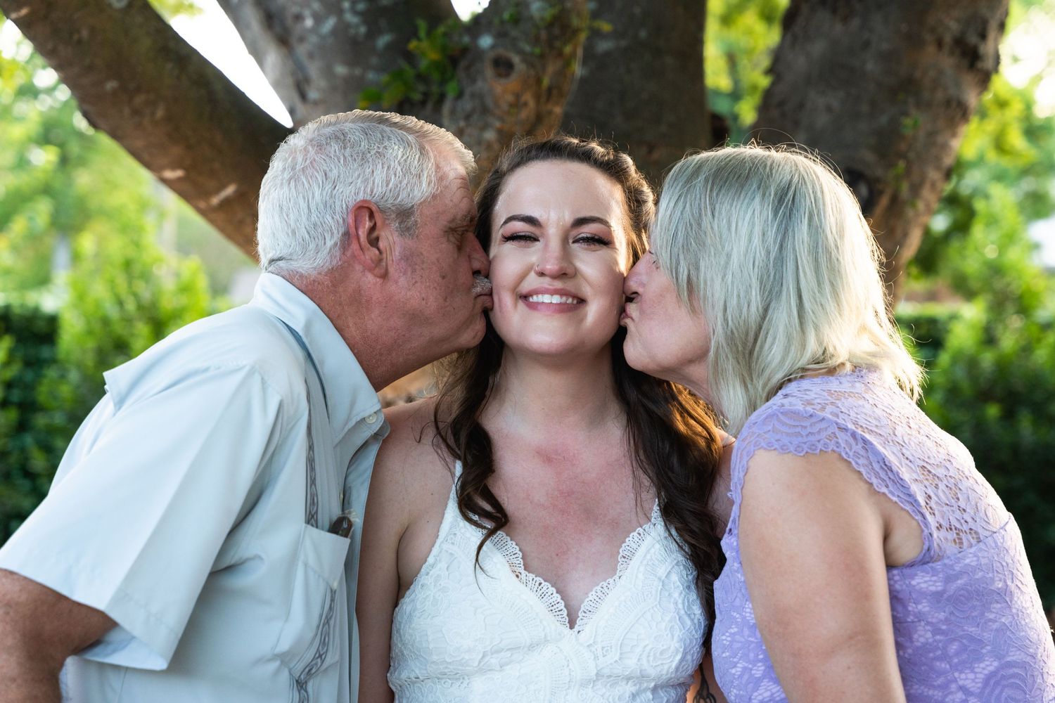 Tender family moment captured outdoors with affectionate gestures.