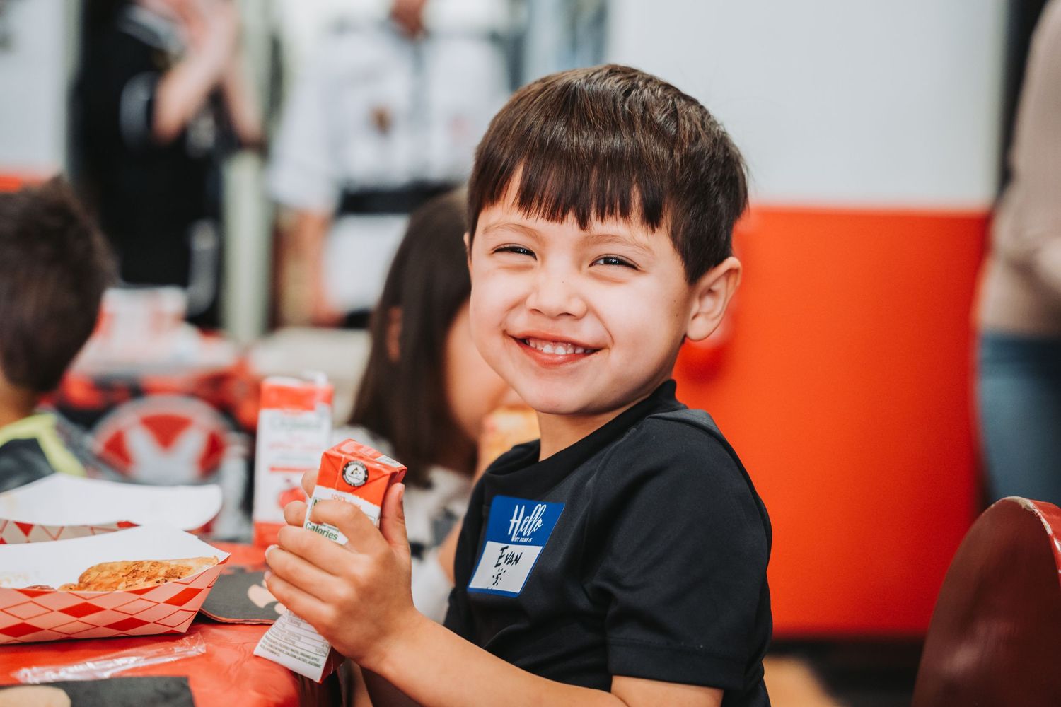 Student enjoying pizza and snacks during a martial arts studio party celebration.