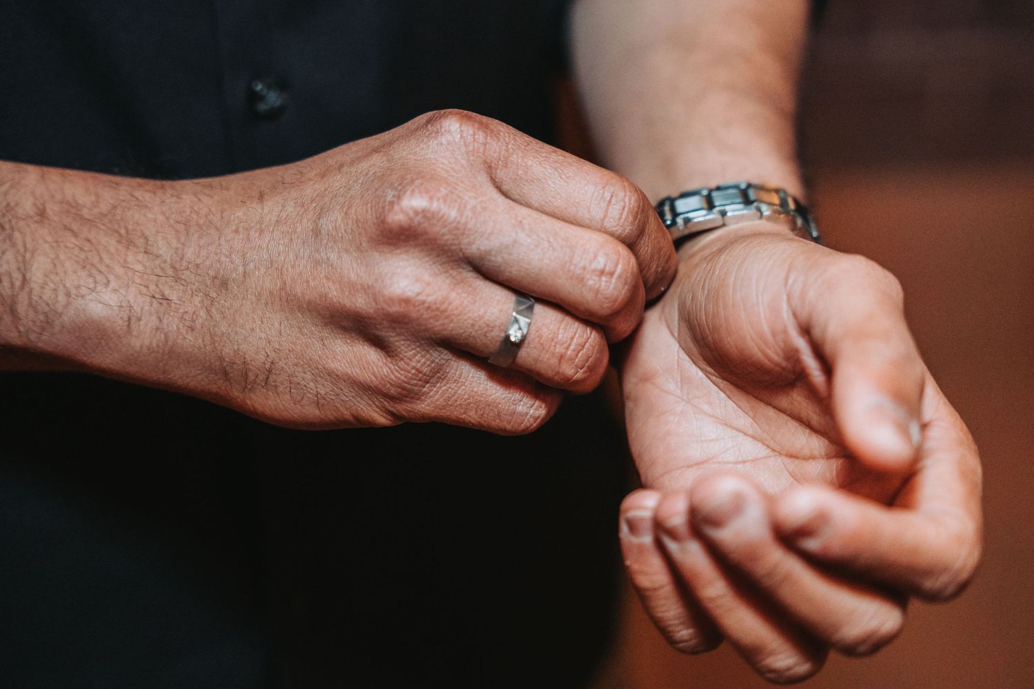Close-up of hands showing rings and jewelry in natural lighting.
