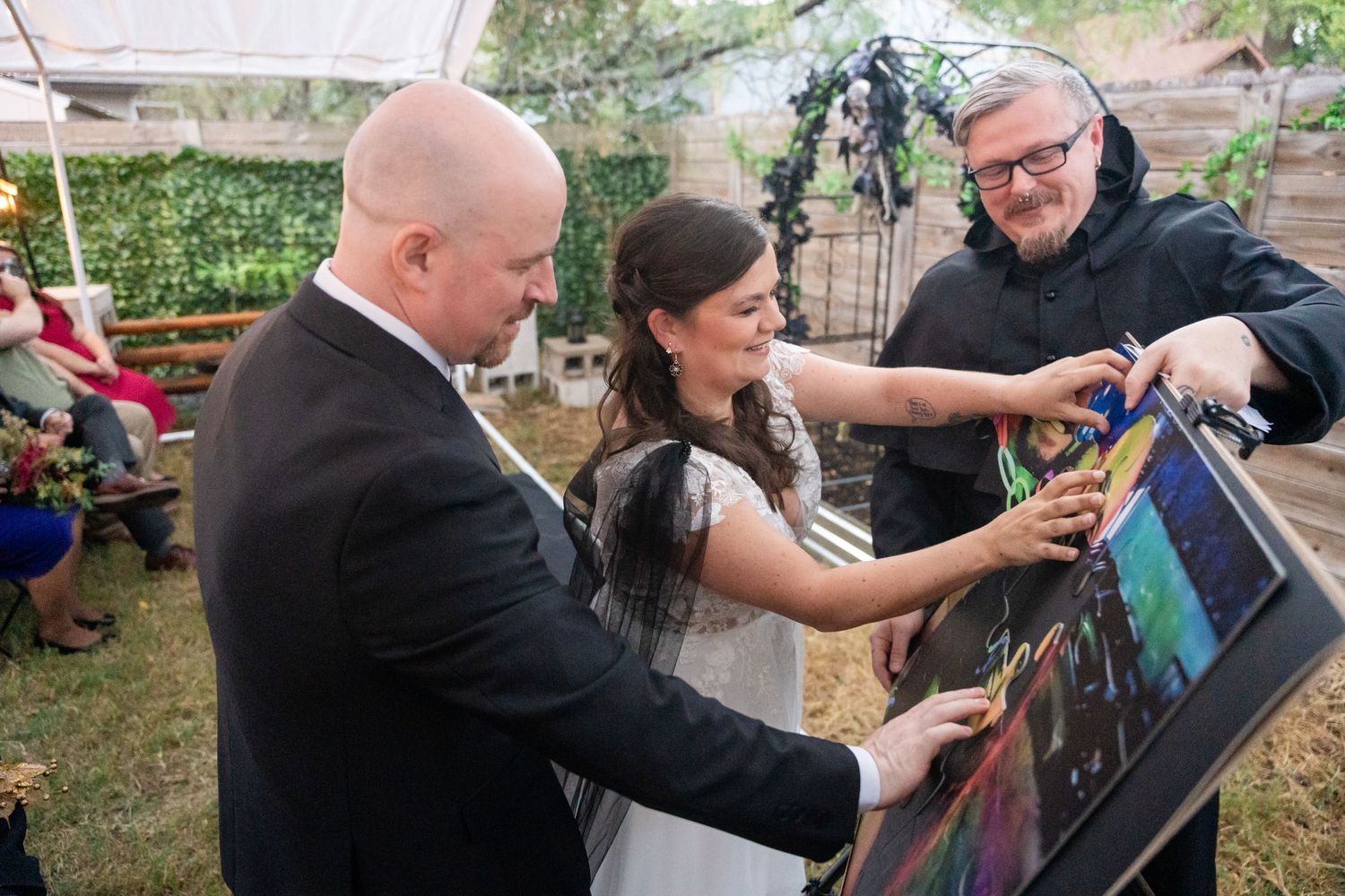 Guests interacting with artwork display during outdoor wedding reception.