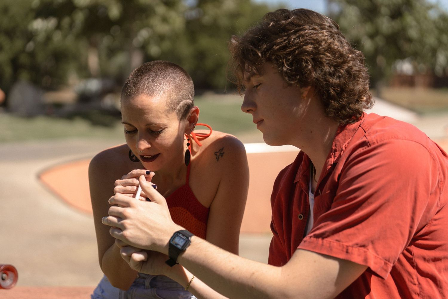 Friends hanging out and sharing a moment at an outdoor skate park.