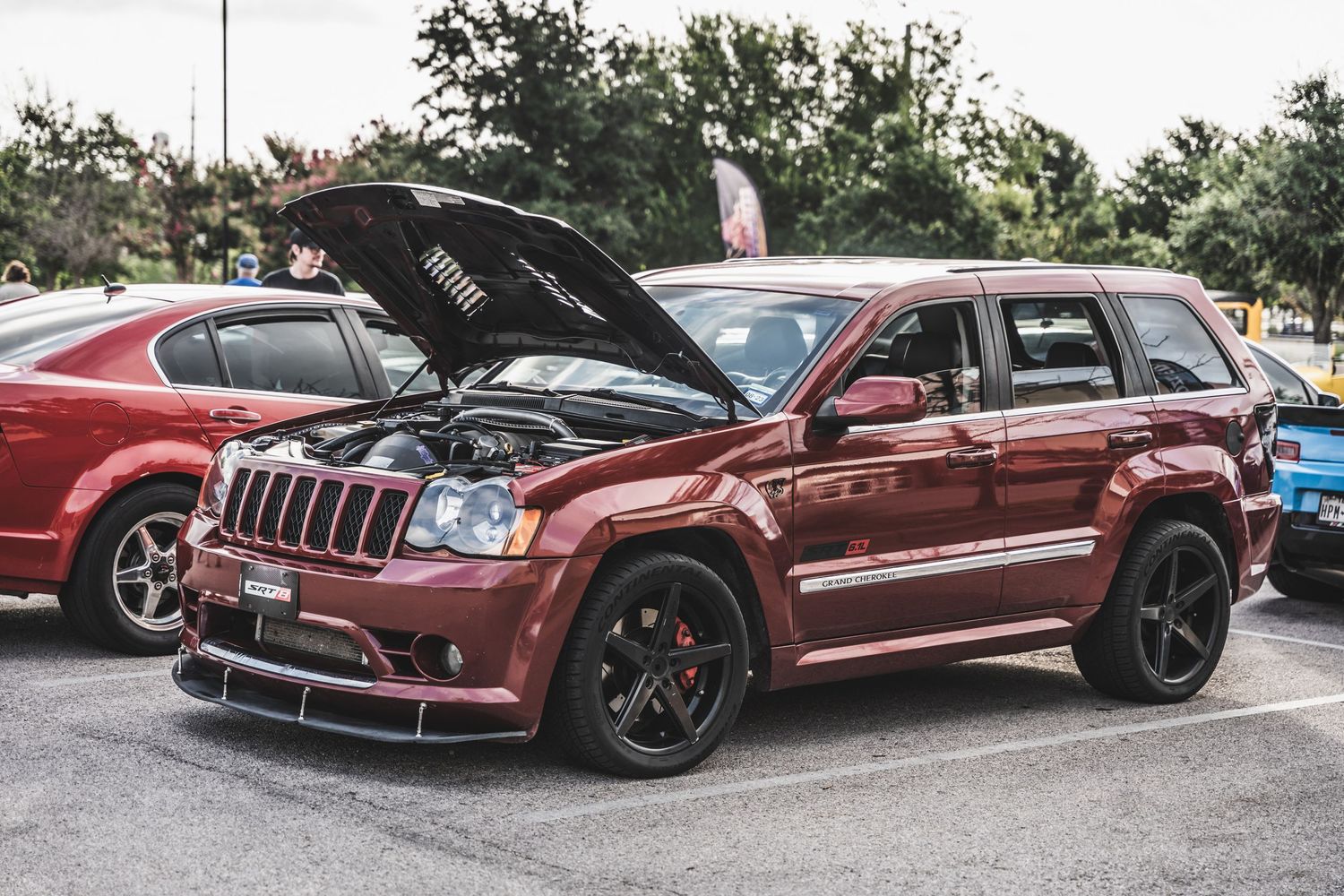 Modified maroon Jeep Grand Cherokee SRT8 with custom wheels and performance upgrades.