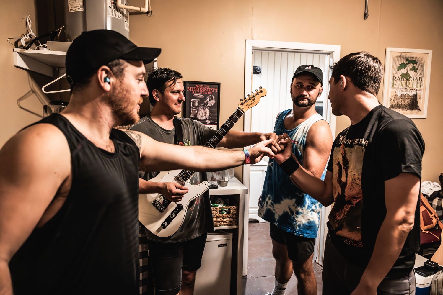 Band members having an animated discussion in a rehearsal space.