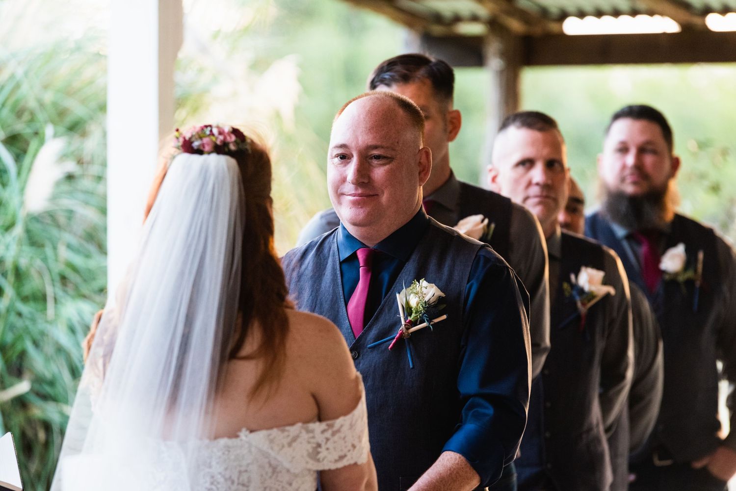 An emotional wedding ceremony moment with attendants looking on.