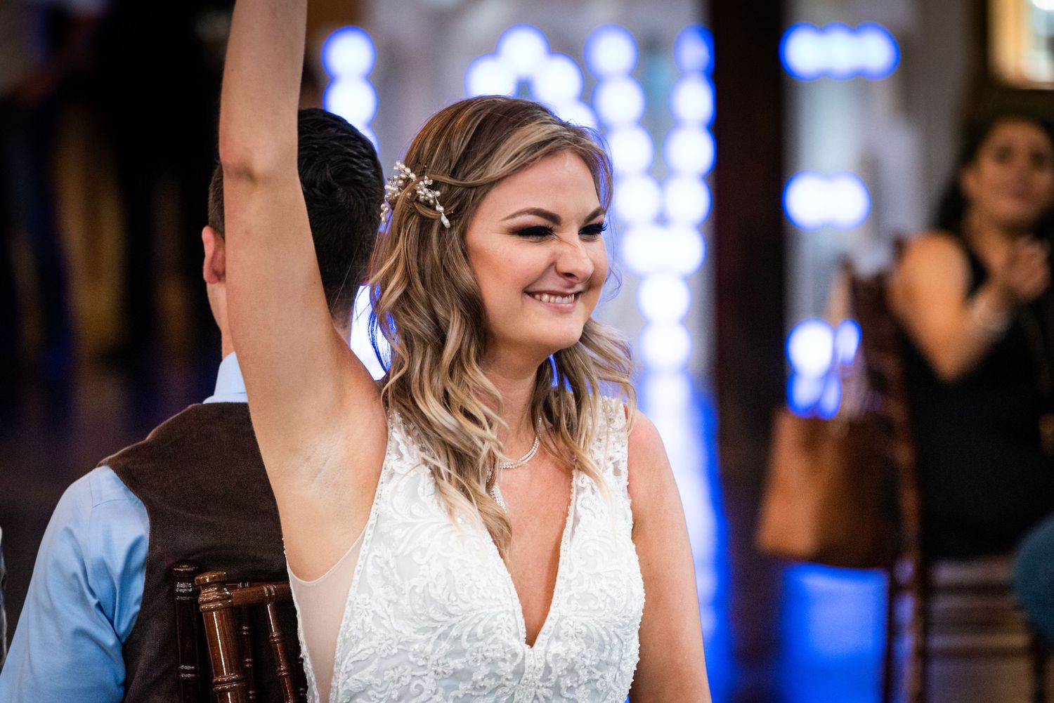 A celebration moment captured during a wedding reception with blue lights and rustic wooden decor.