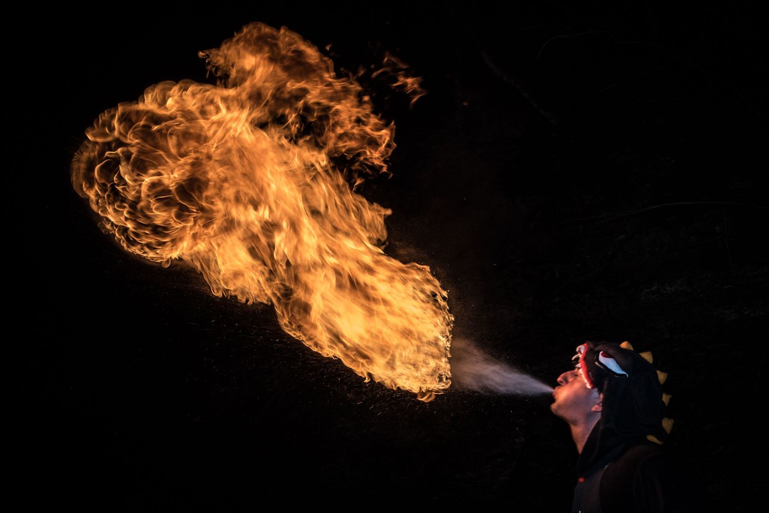 A sequence of six dramatic fire breathing performances showing bright orange flames against a dark background.