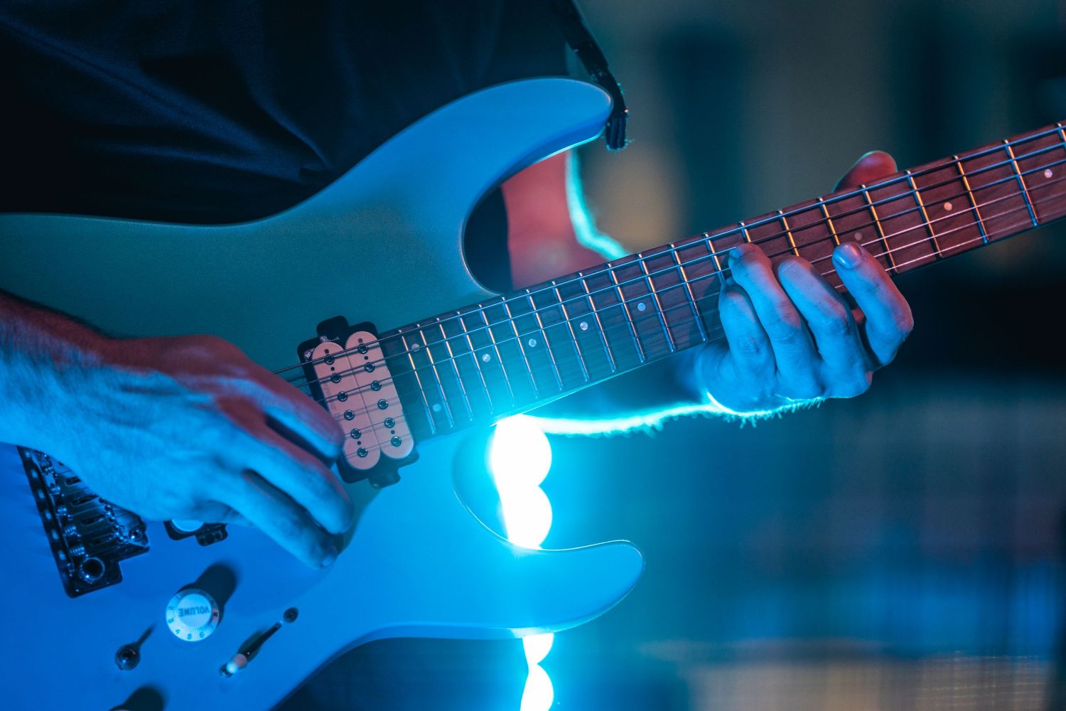 Close-up shots of electric guitar playing with glowing blue light effects creating an atmospheric performance scene.