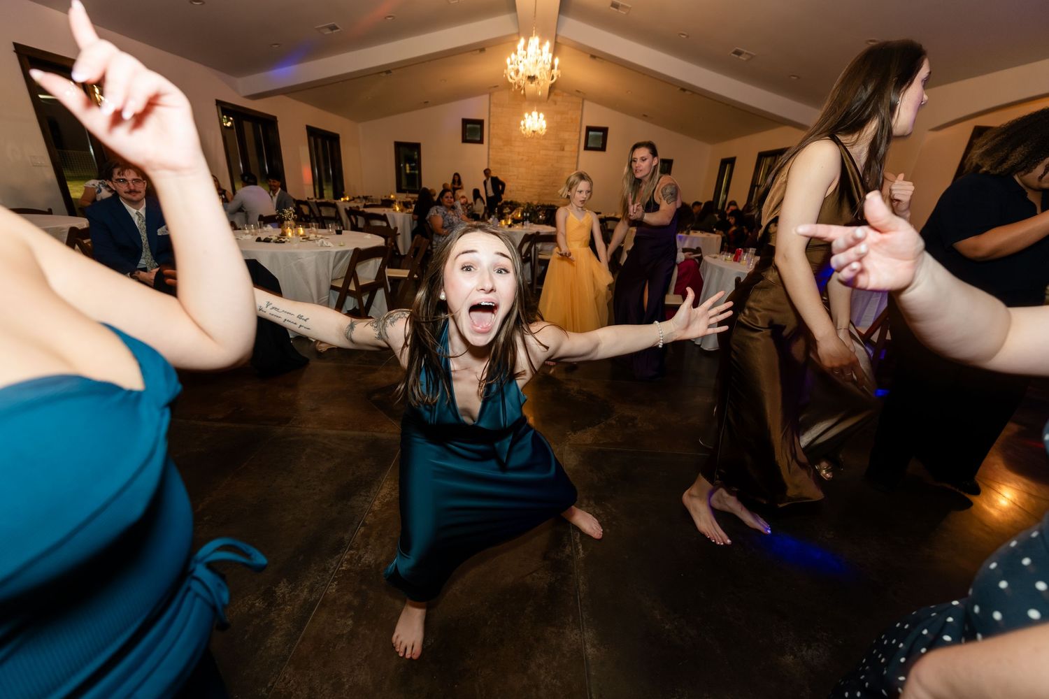 Guests dancing energetically at a wedding reception in an elegant banquet hall.