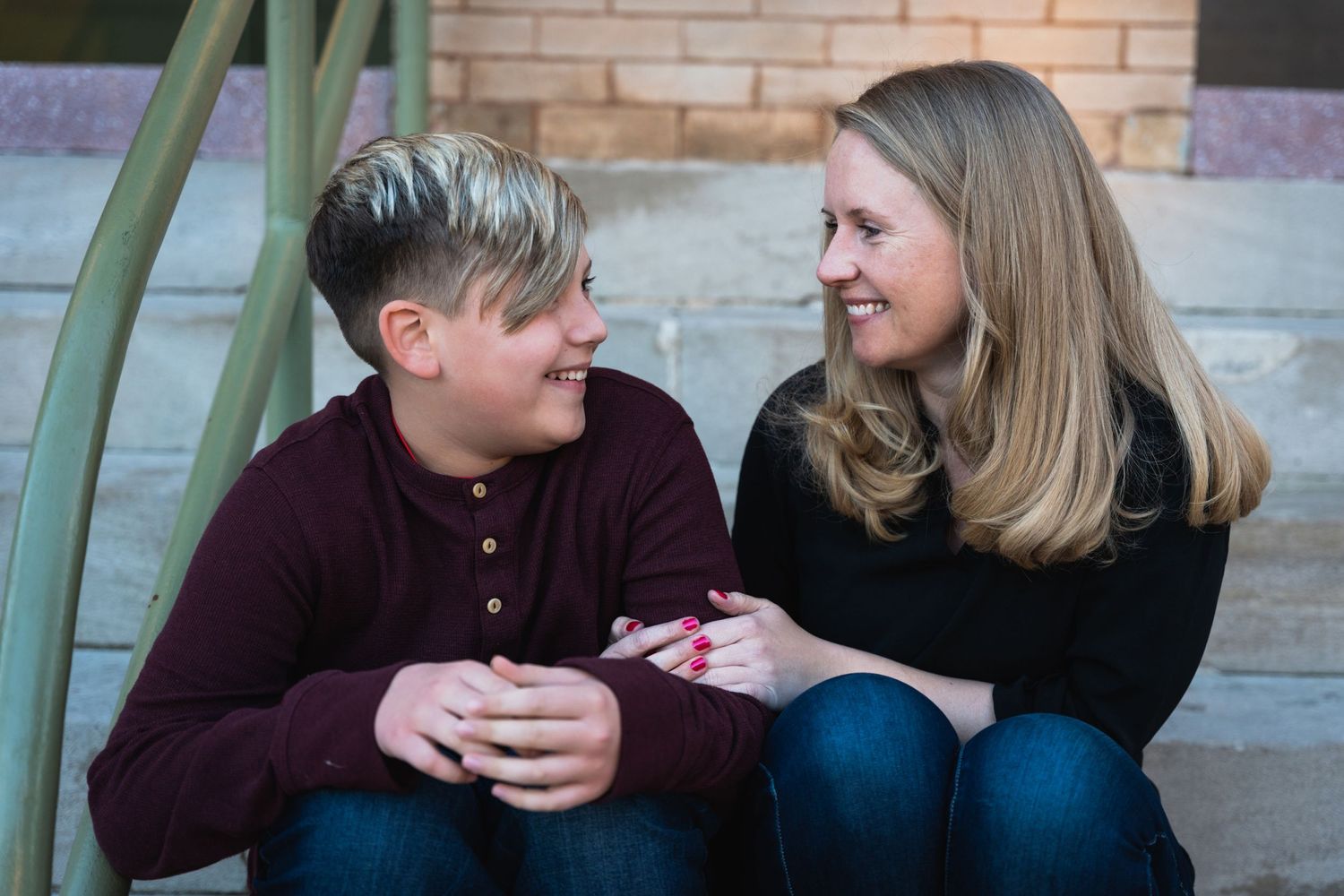 Candid moment of two people sitting on steps sharing a conversation.