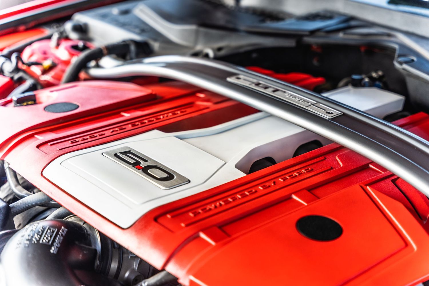 Close-up of a red Honda engine bay showing performance modifications and engine cover.