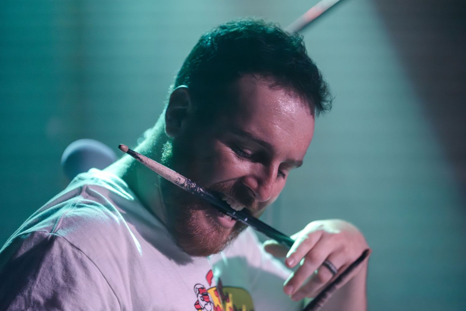 Close-up shot of musician performing with microphone in atmospheric lighting.