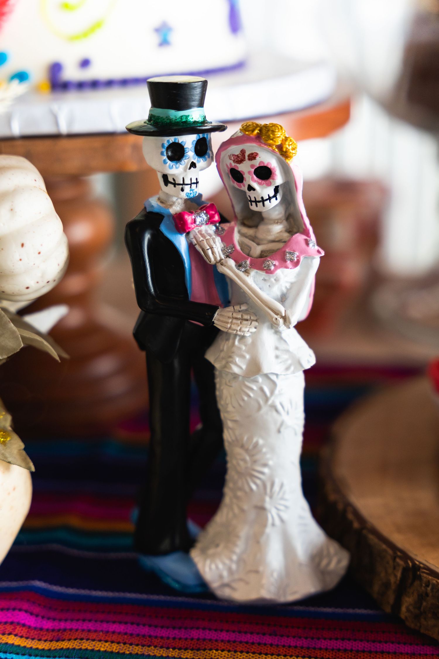 Day of the Dead themed wedding cake topper featuring skeleton bride and groom figurines.
