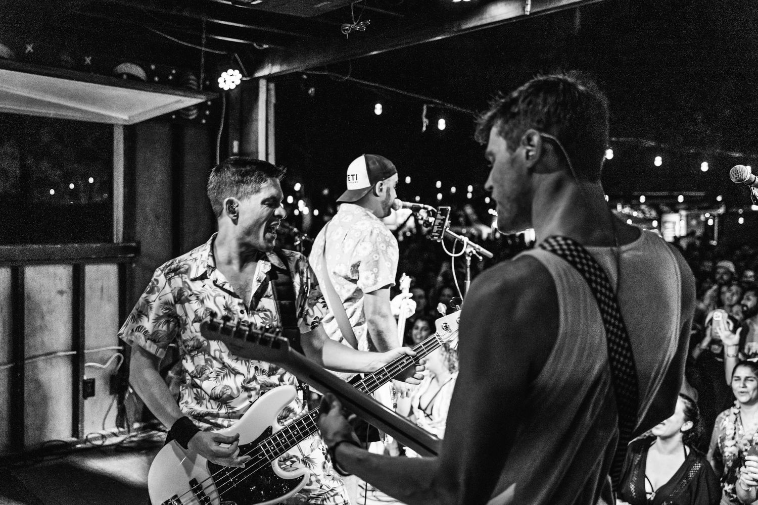 Musicians performing on stage during a black and white concert photograph.