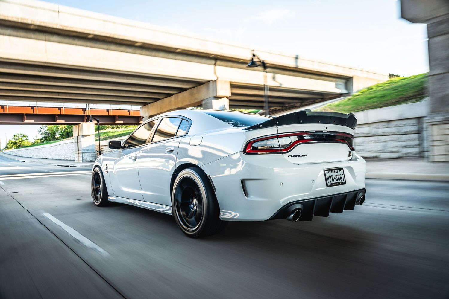Modified Dodge Charger photographed under highway overpass with motion blur effect.