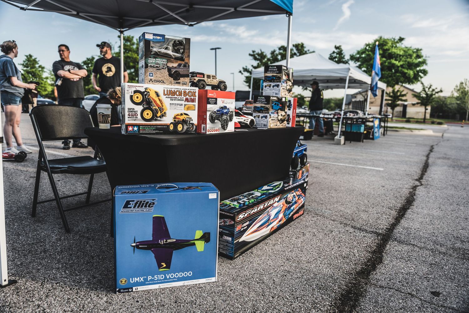 Vendor booth with drone equipment and merchandise at an outdoor market.