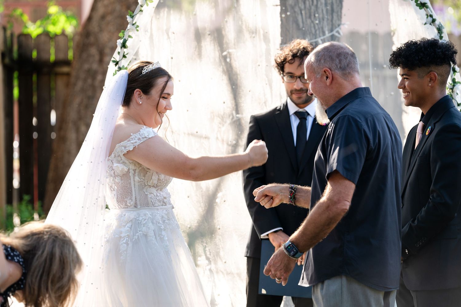 A wedding celebration moment captured outdoors with guests and decorative elements.