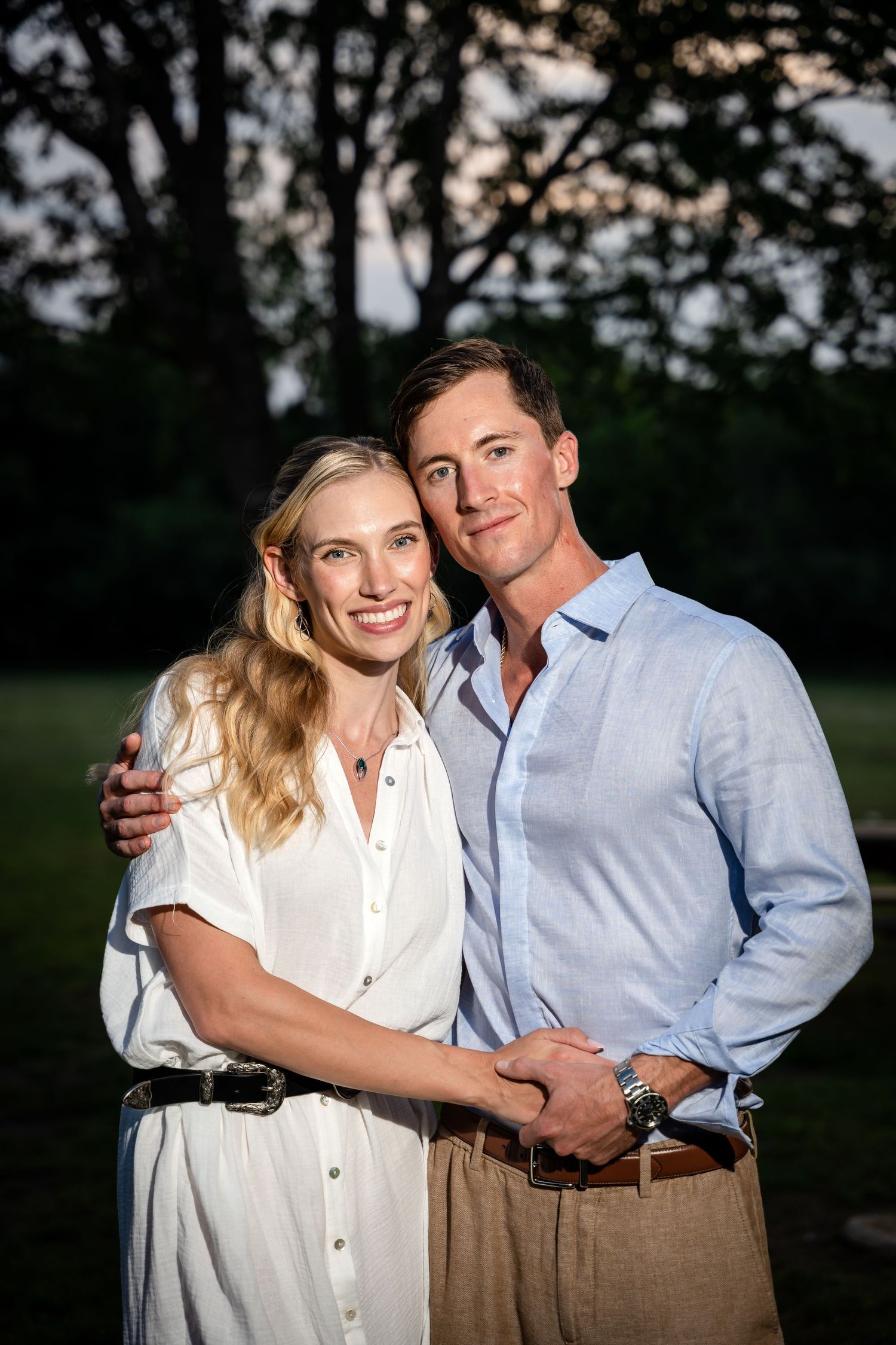 Portrait of a couple in casual elegant attire posing together at twilight.