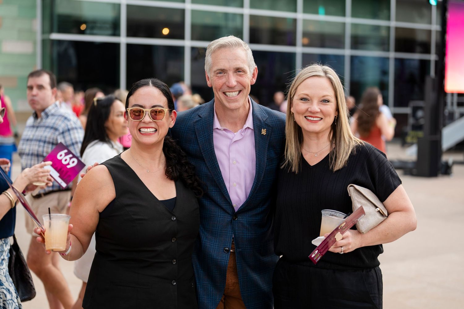A group of people gathered outdoors at a social event wearing casual and business attire.
