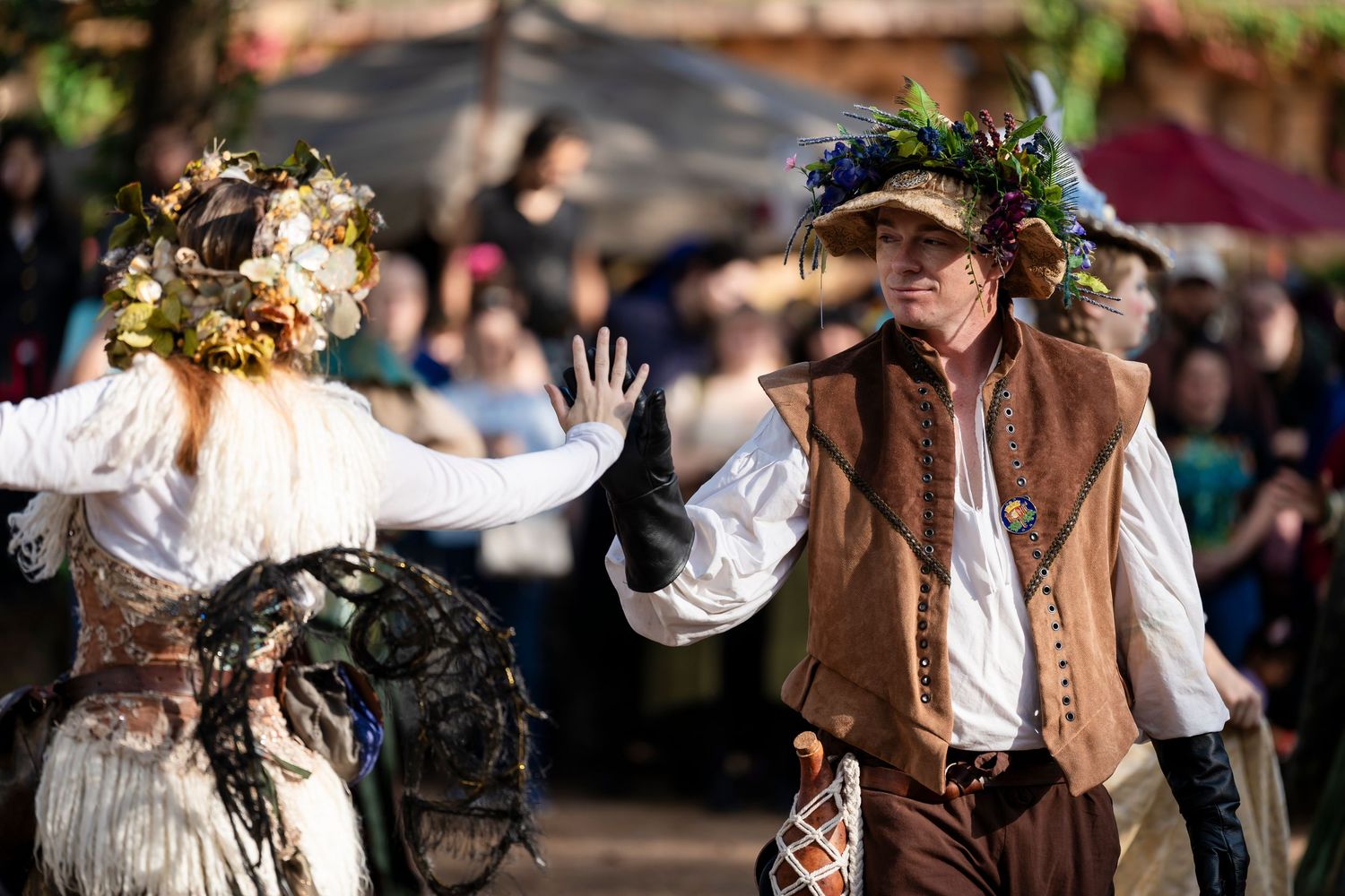 Medieval performers in period costumes dance and entertain at a Renaissance festival.