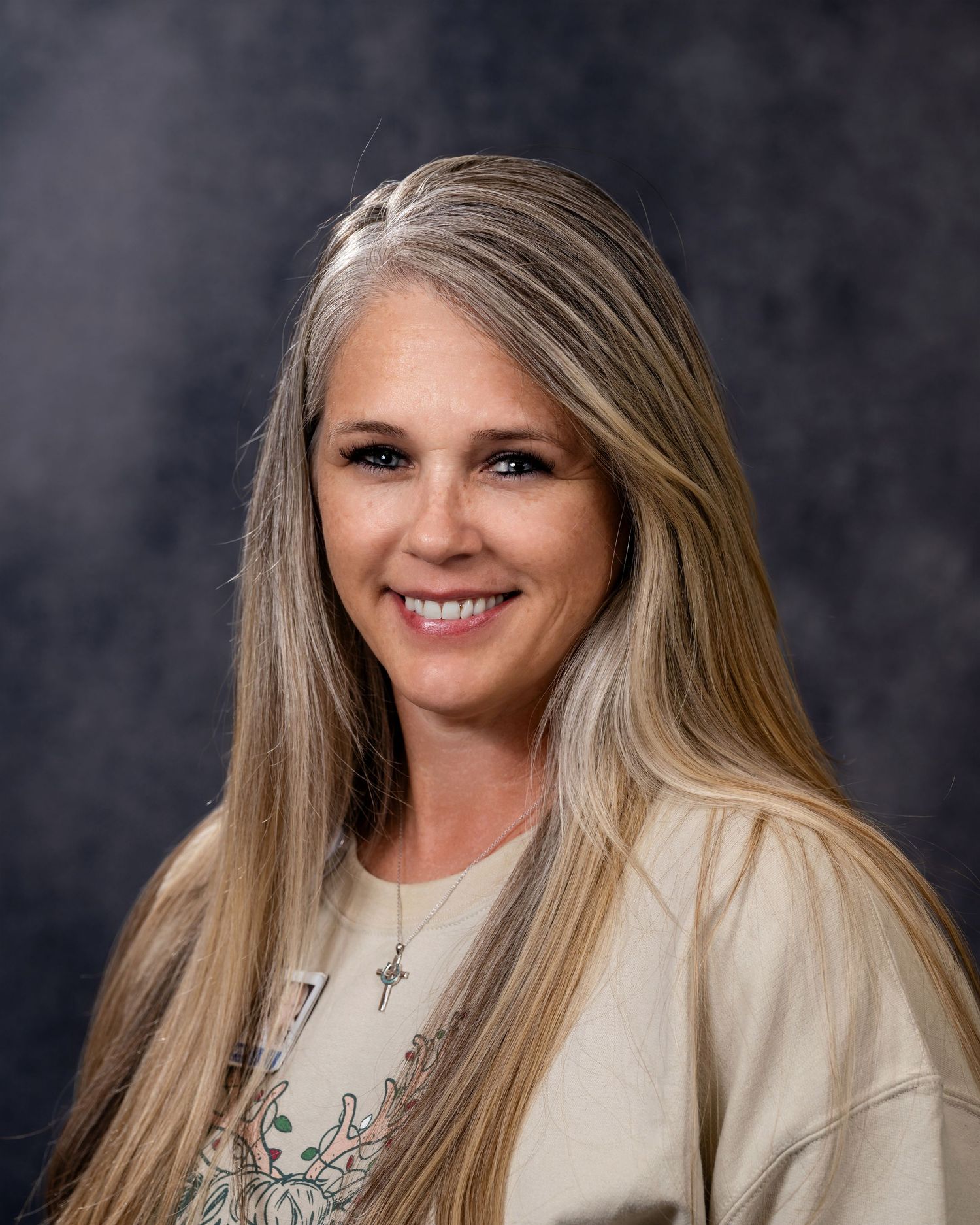 Professional headshot series showing warm smiles against dark background wearing cream colored top.
