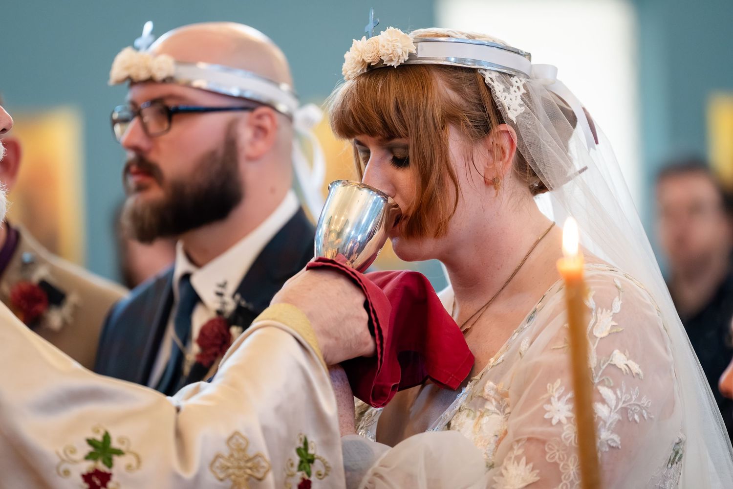 Wedding guests enjoying drinks and conversation at an elegant reception with warm lighting and festive atmosphere.