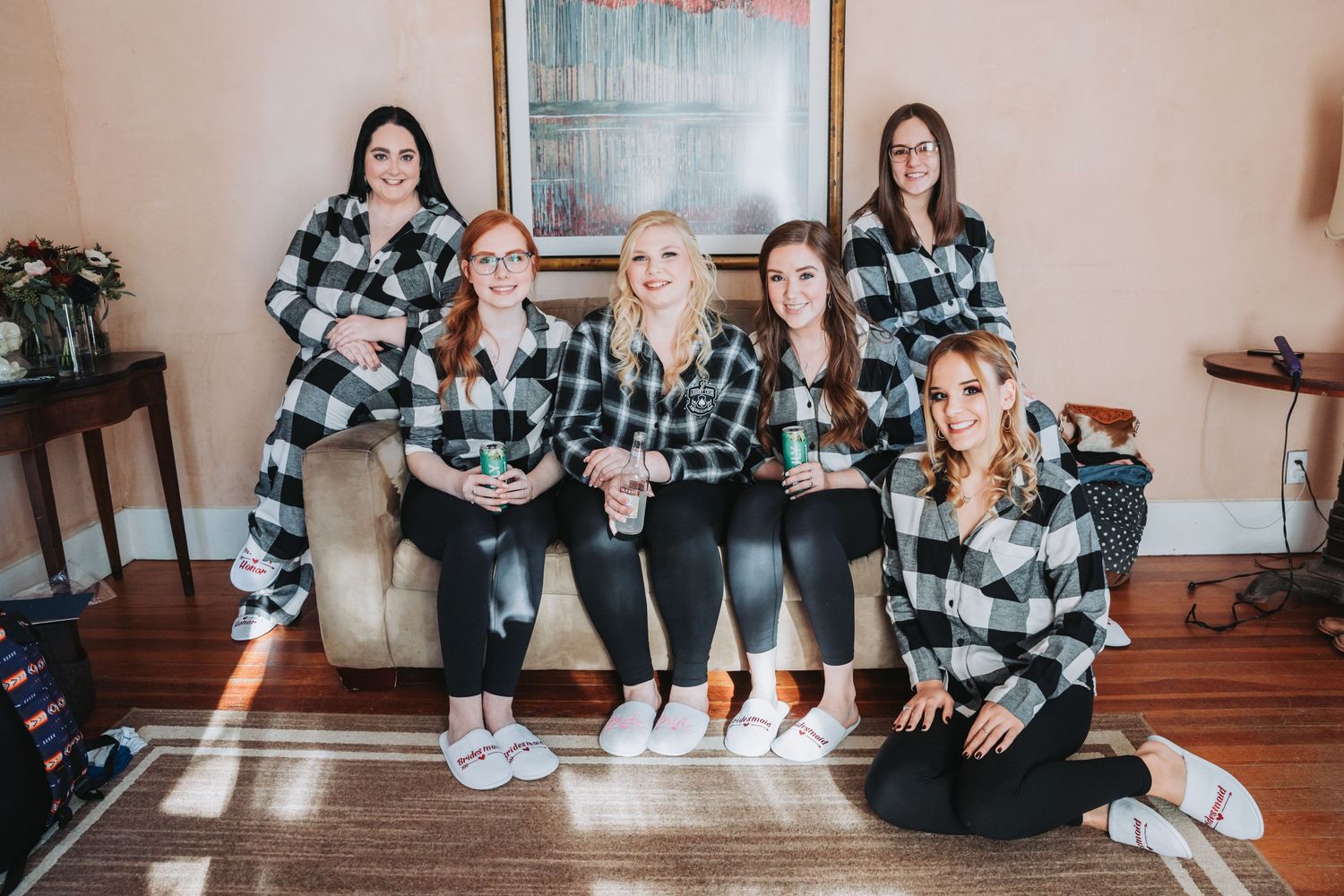 Wedding party wearing matching black and white buffalo plaid shirts posing indoors.