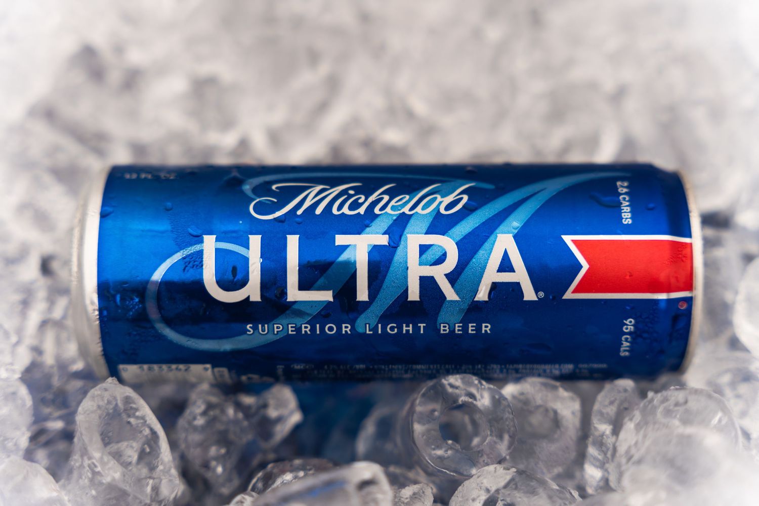 A single blue Michelob Ultra beer can resting on ice.