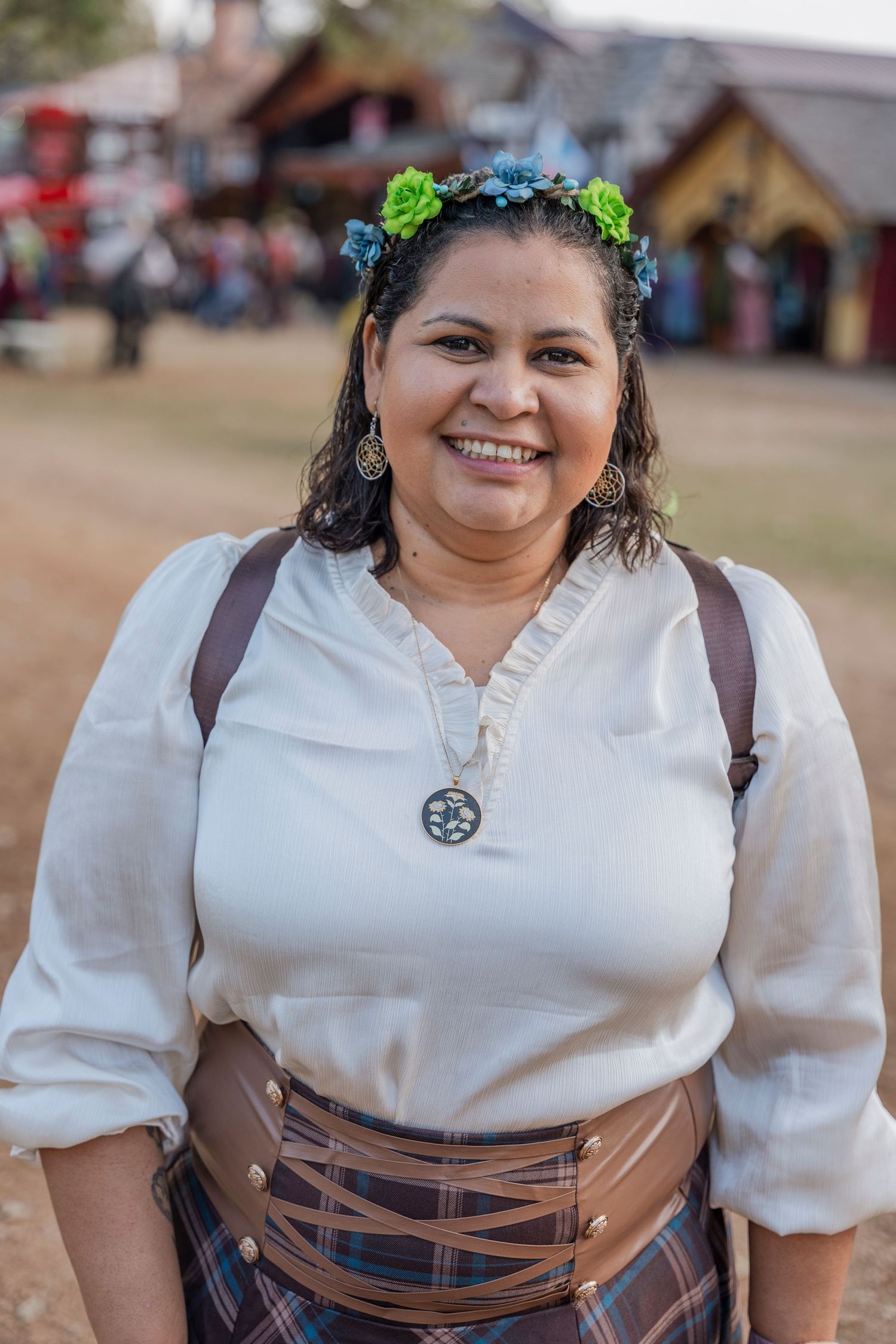 Renaissance festival attendee wearing flower crown and period costume.