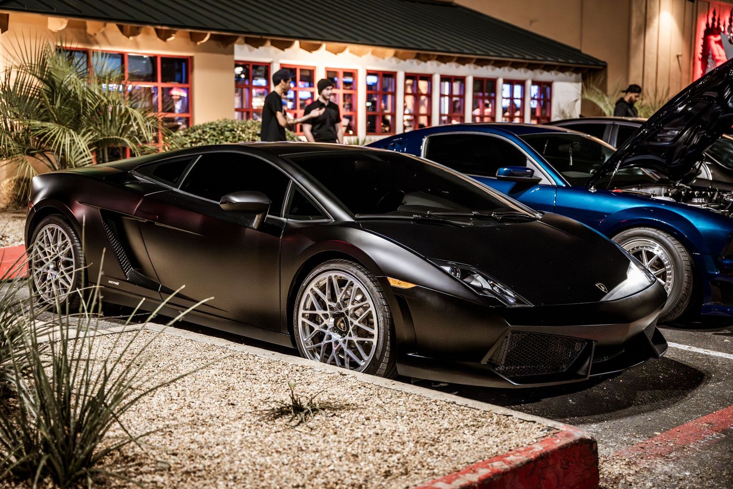 Black Lamborghini Gallardo parked at night showing off custom wheels and sport styling.