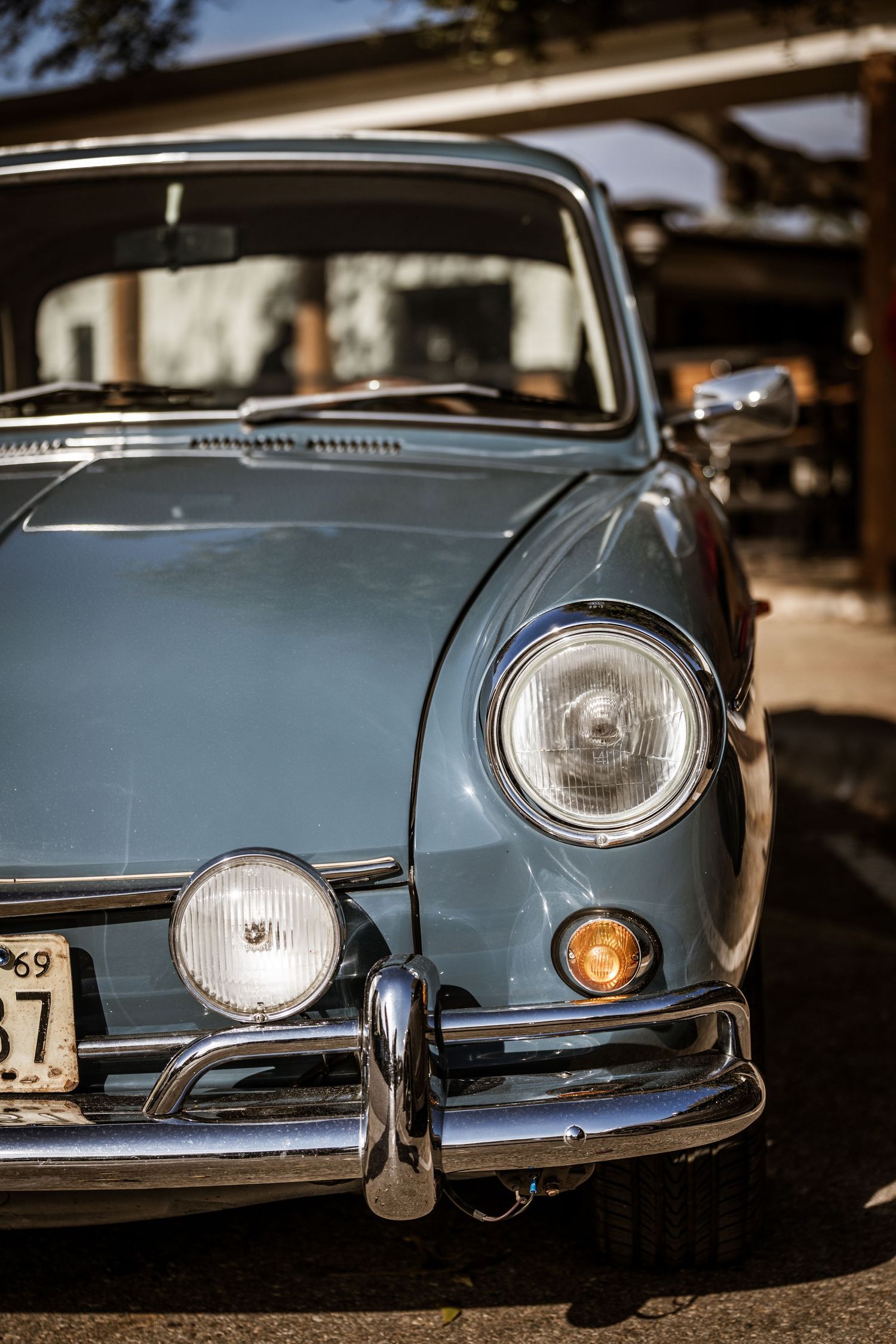 Front quarter view of a classic light blue Volkswagen showing distinctive round headlights and chrome bumper.