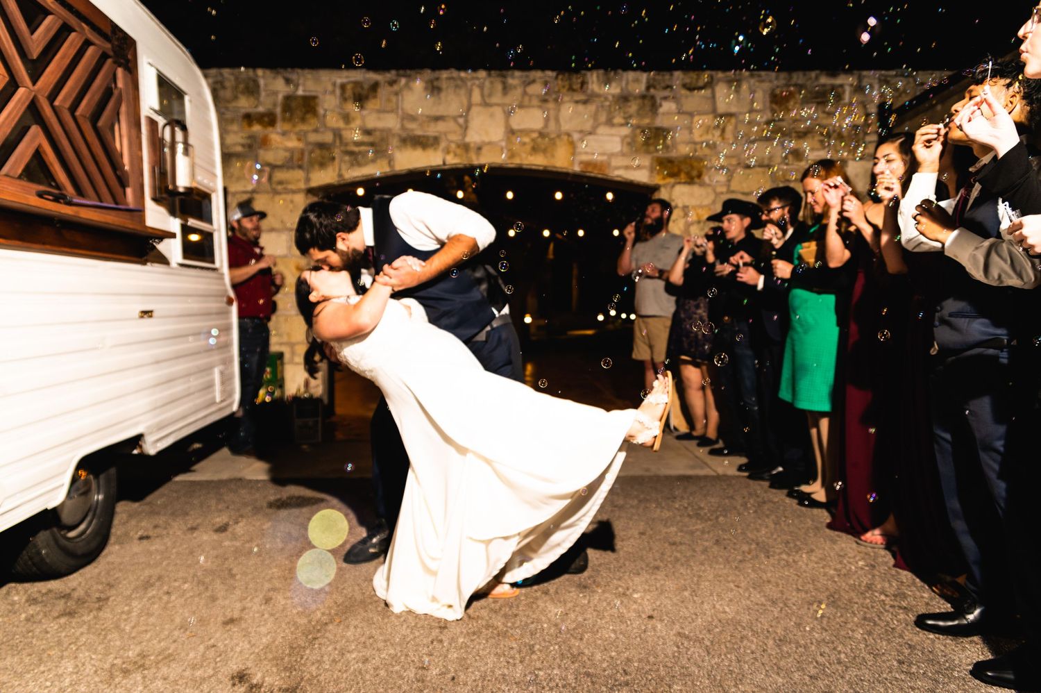 A romantic dip dance move performed at a wedding celebration with guests watching.