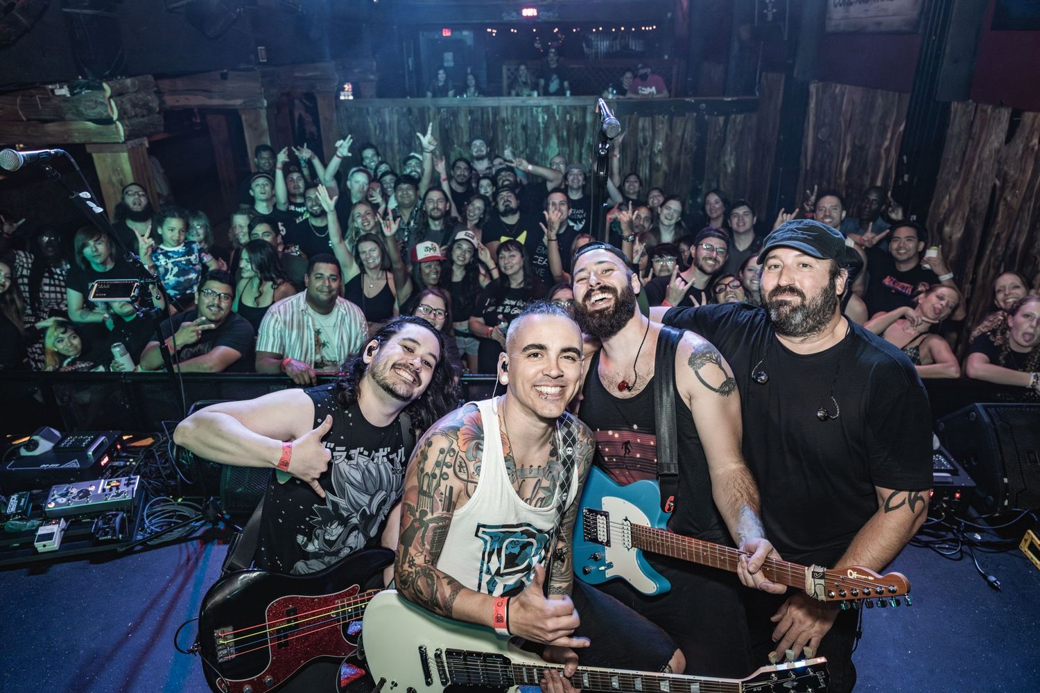 Energetic crowd and performers celebrate during live music performance at intimate venue.