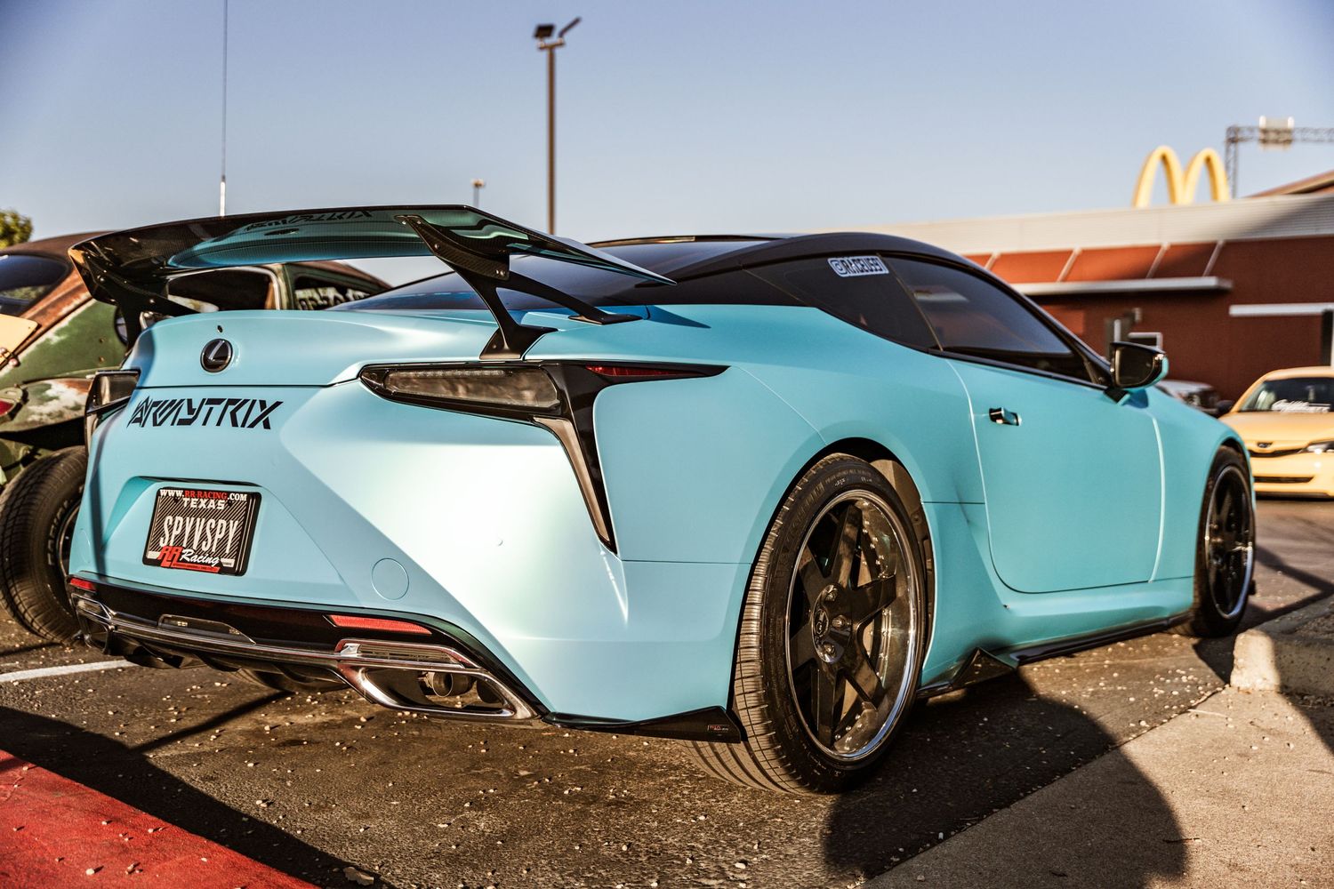 Teal colored Lexus LC500 with aftermarket wheels displayed at car meet.