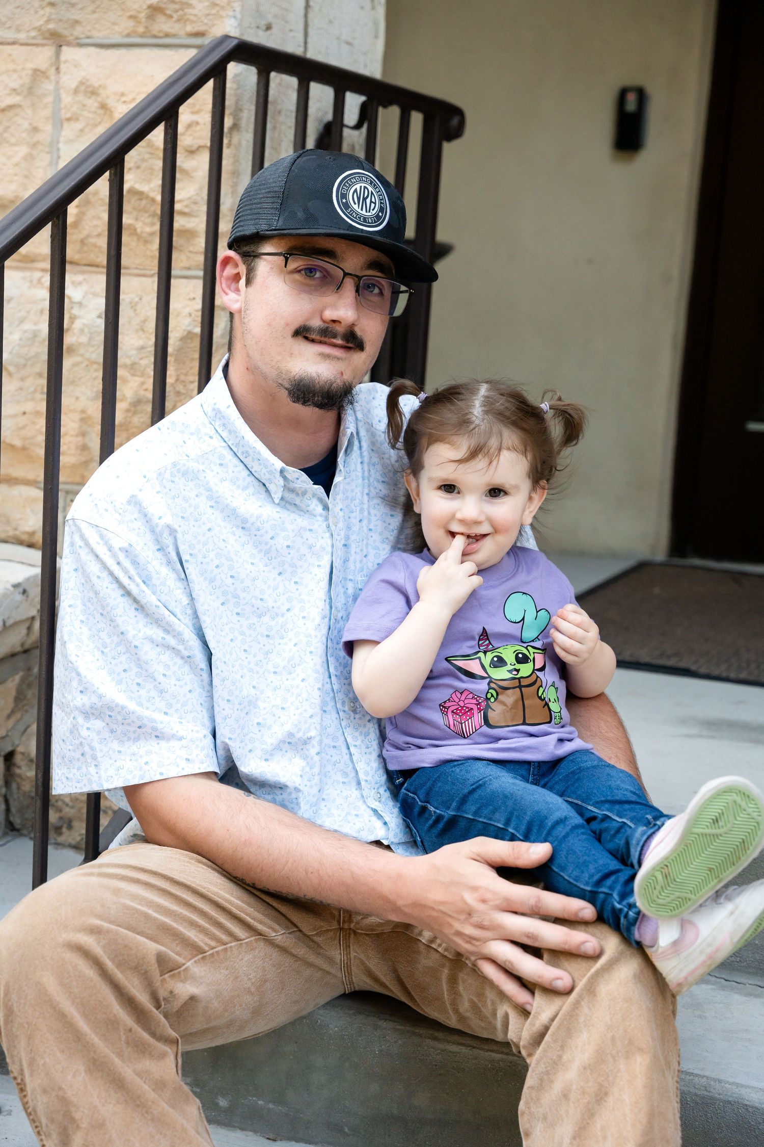 Father and child sitting together on outdoor steps.