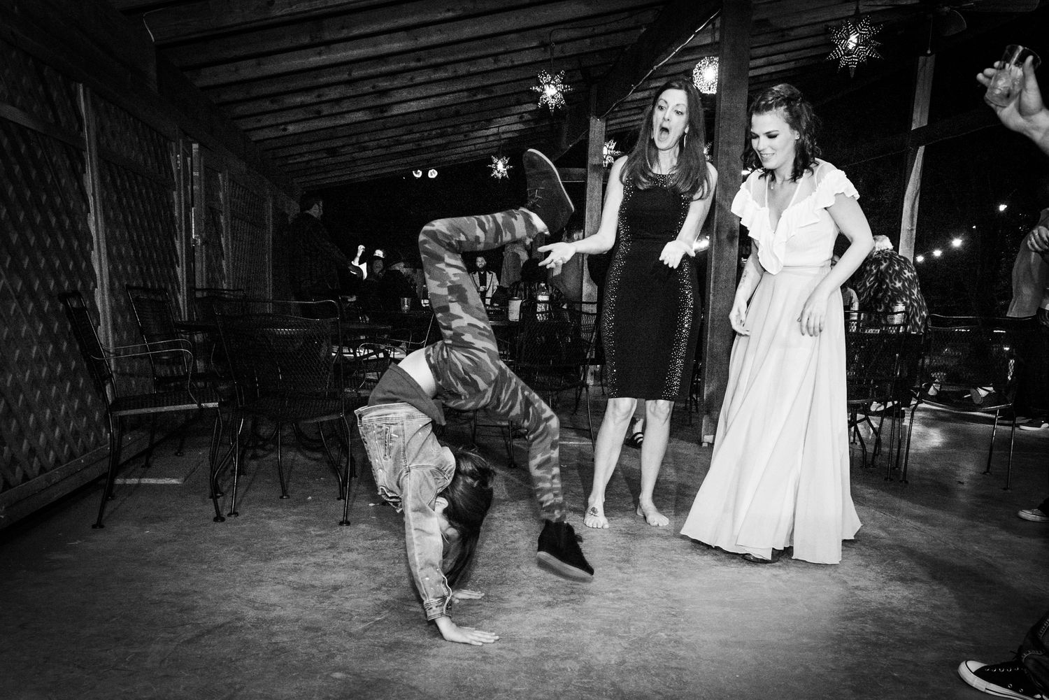 Military personnel and wedding guests dance and celebrate together at a reception venue.